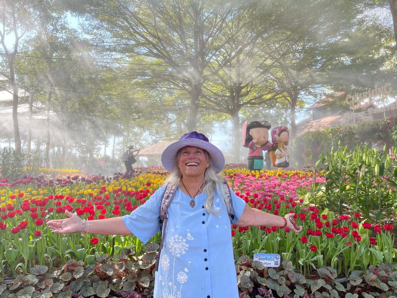 Catherine Whittall smiling in a flower garden